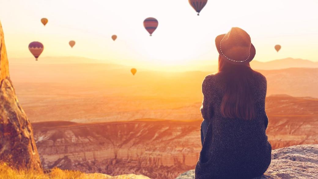 Eine Frau steht vor einem Horizont mit einigen Ballons