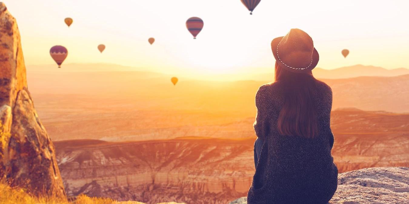 Eine Frau steht vor einem Horizont mit einigen Ballons