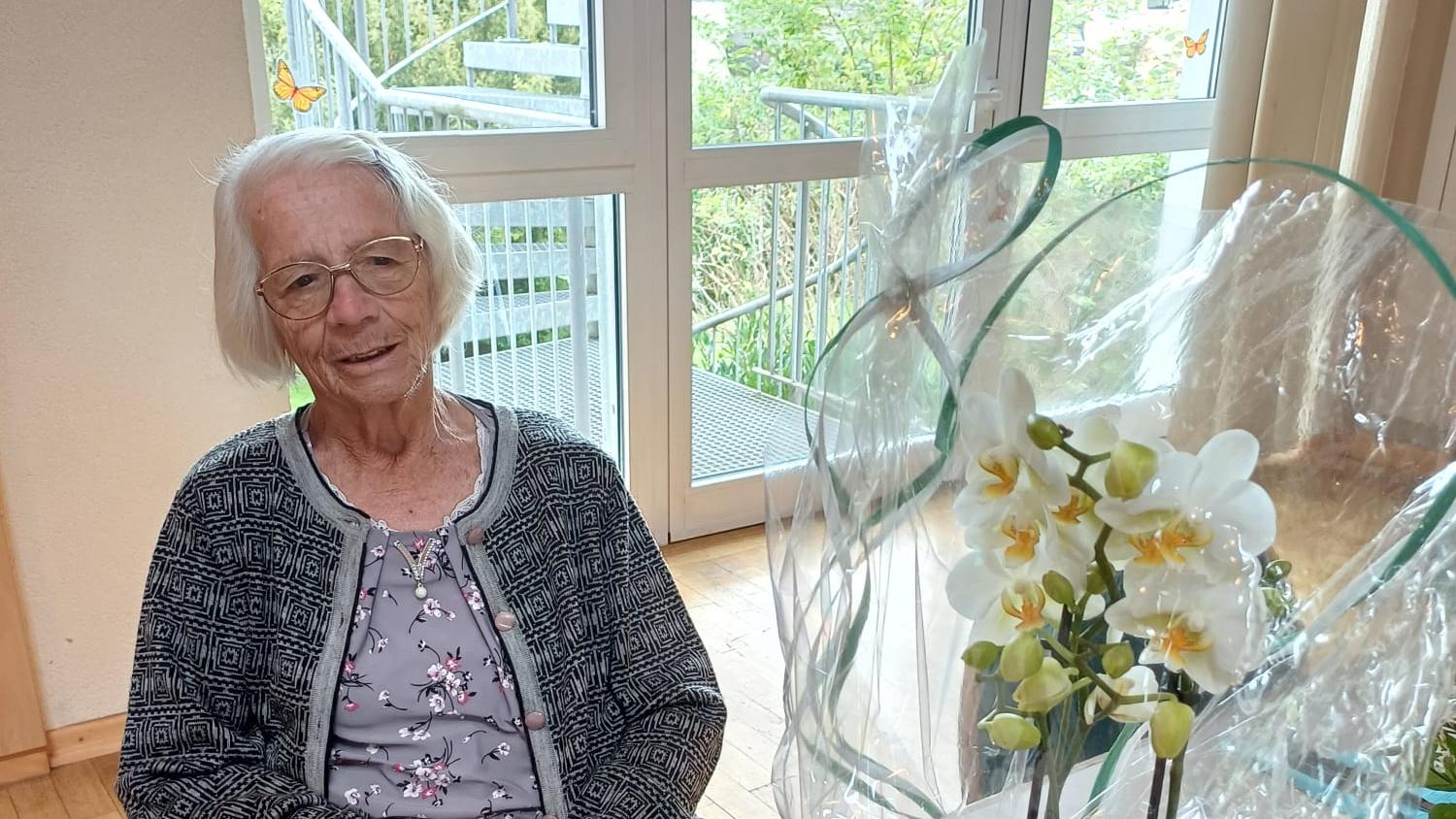 Geburtstagskind Rosi Ott vor einem Blumenstrauß in der Freitagsküche in Wadern