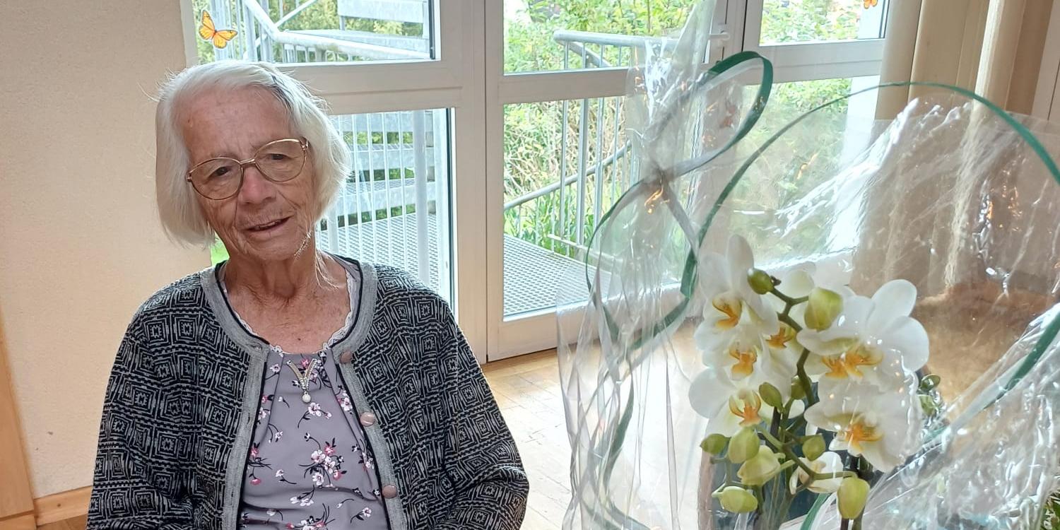 Geburtstagskind Rosi Ott vor einem Blumenstrauß in der Freitagsküche in Wadern