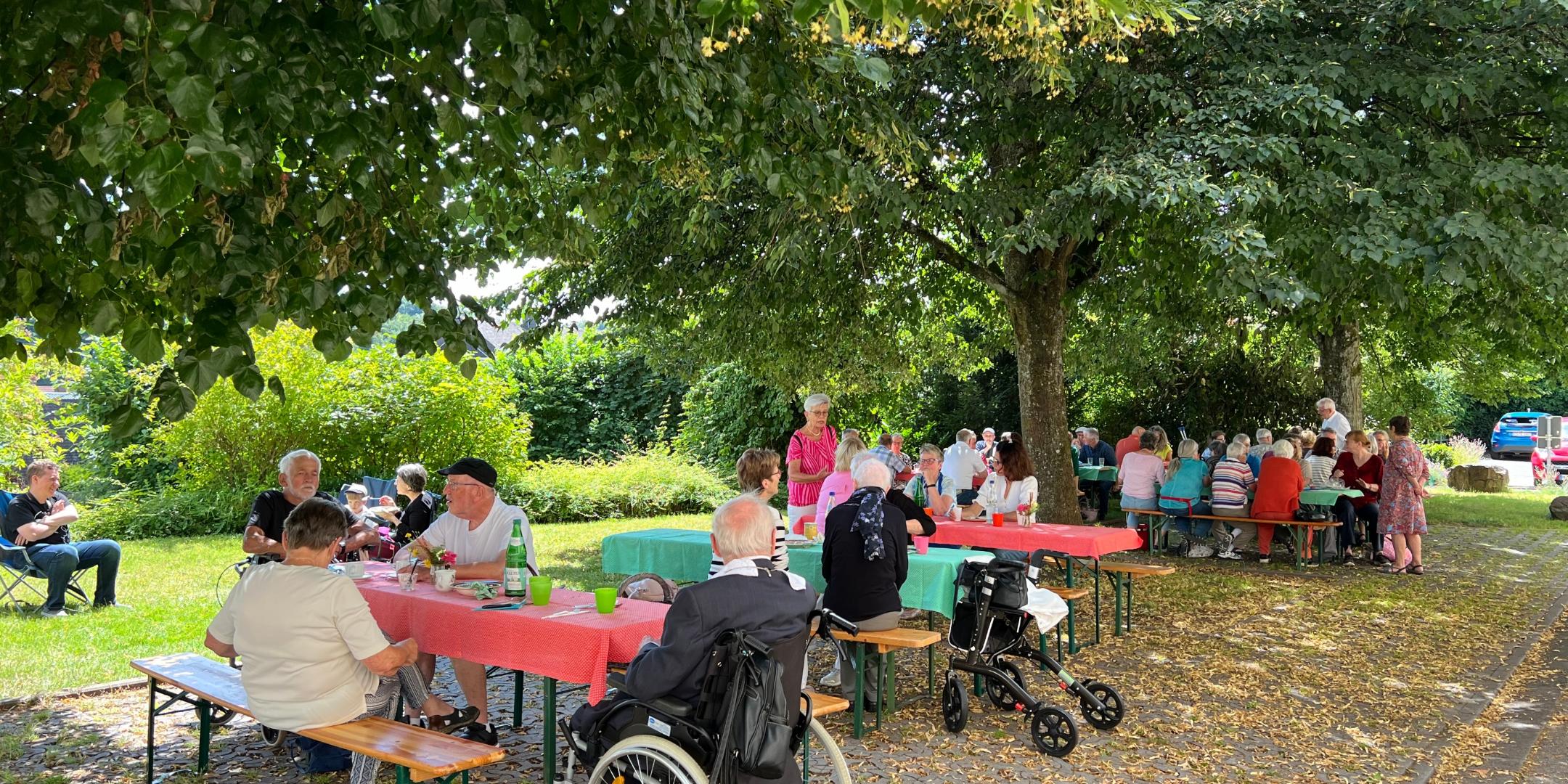 Menschen sitzen unter Bäumen