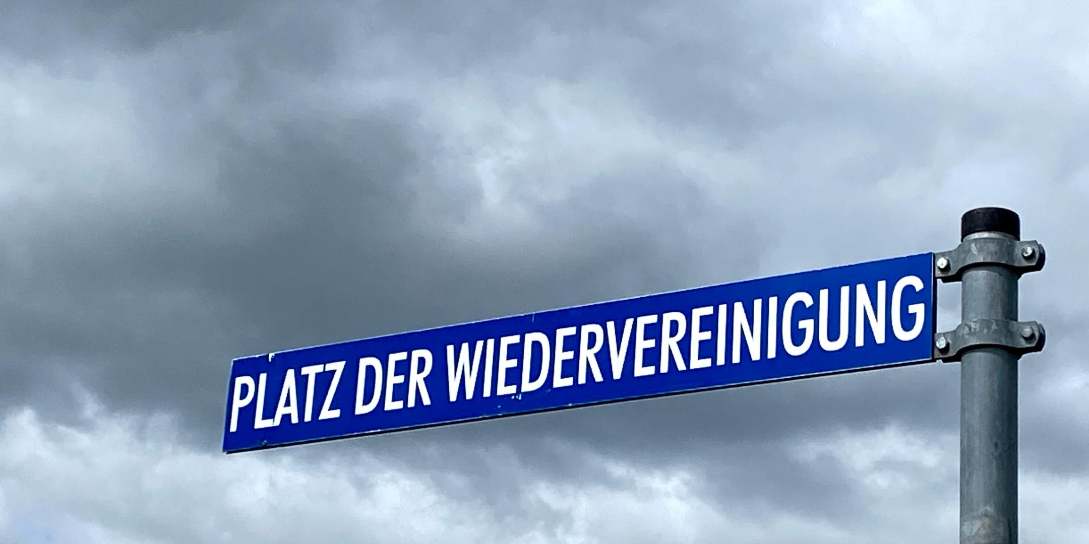 Ein Straßenschild 'Platz der Wiedervereinigung'