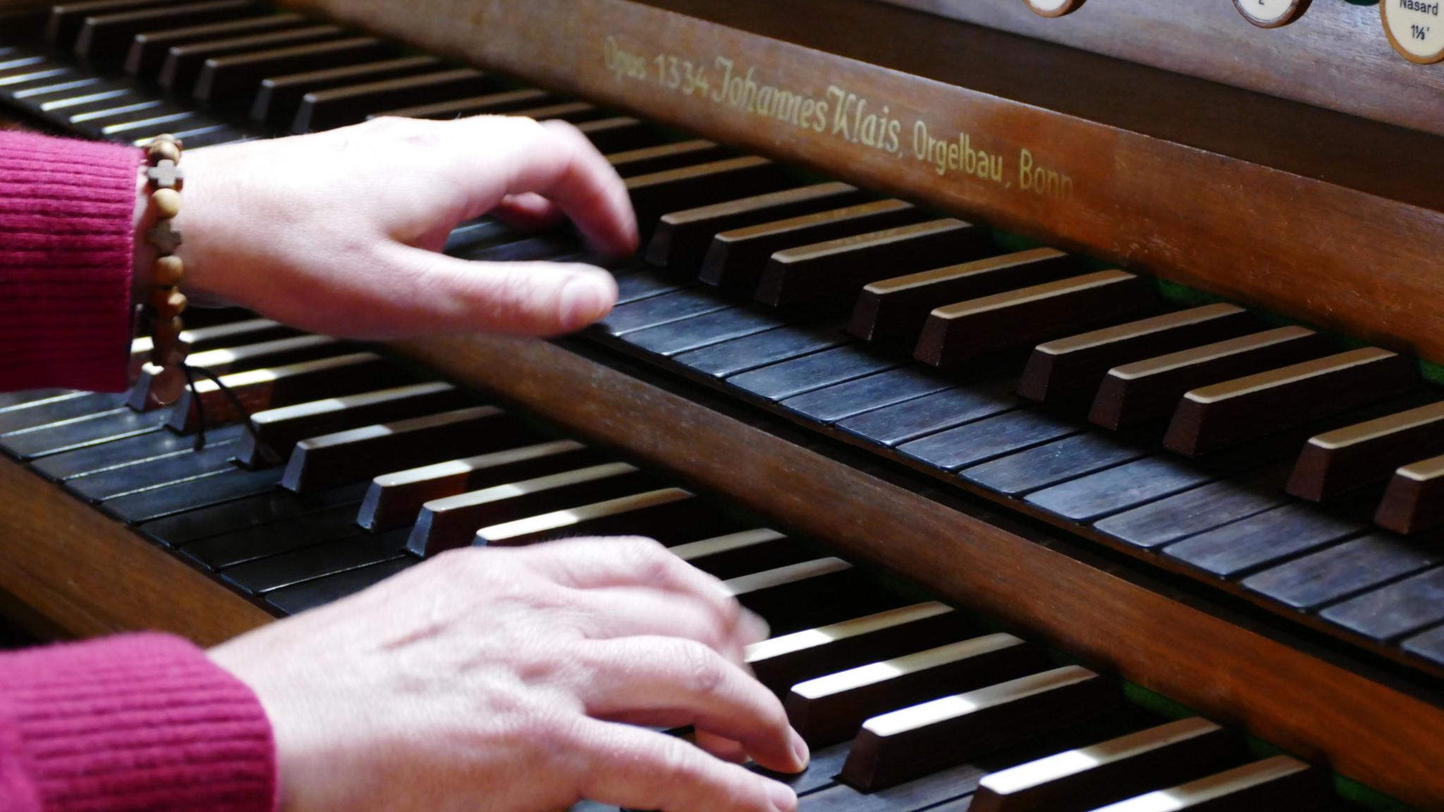 Orgel spielende Hände am Notenpult